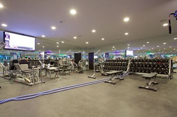 Spacious fitness center with weight equipment and screens